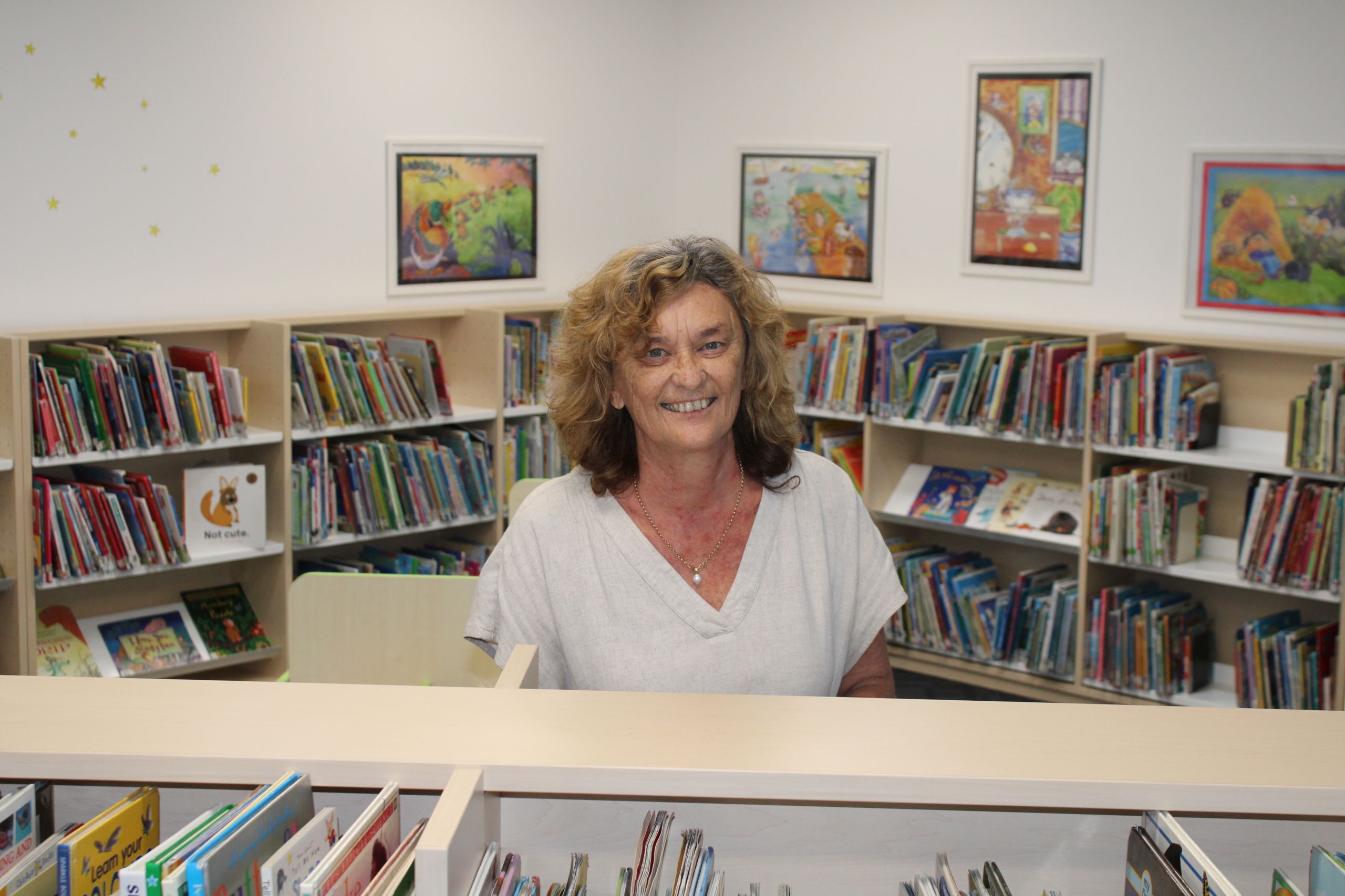 a woman standing behind a counter in a library.
