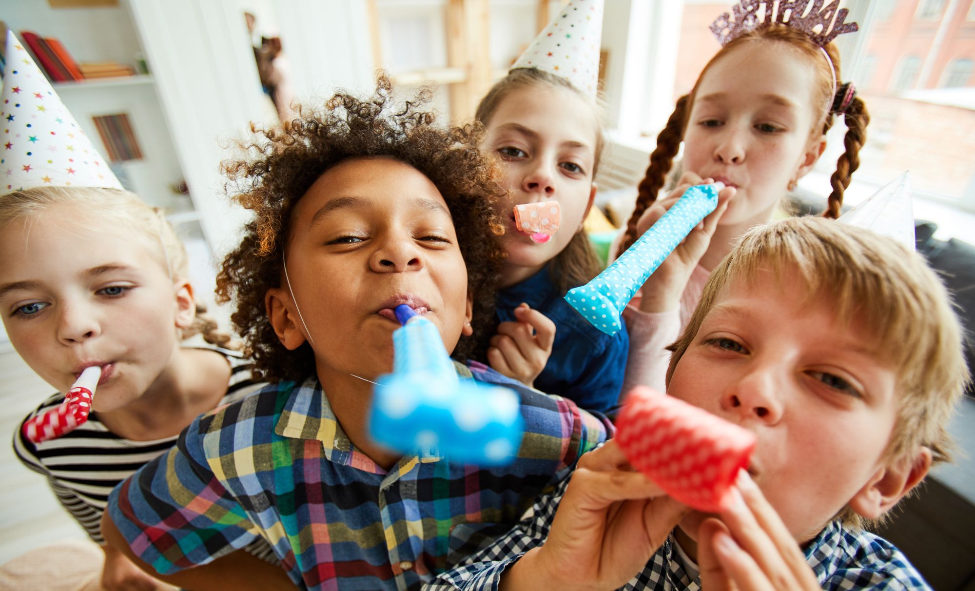 a group of kids blowing party blowers