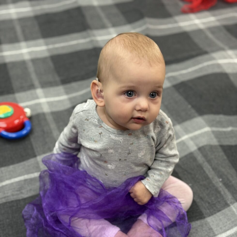 Baby looking to camera with a purple scarf