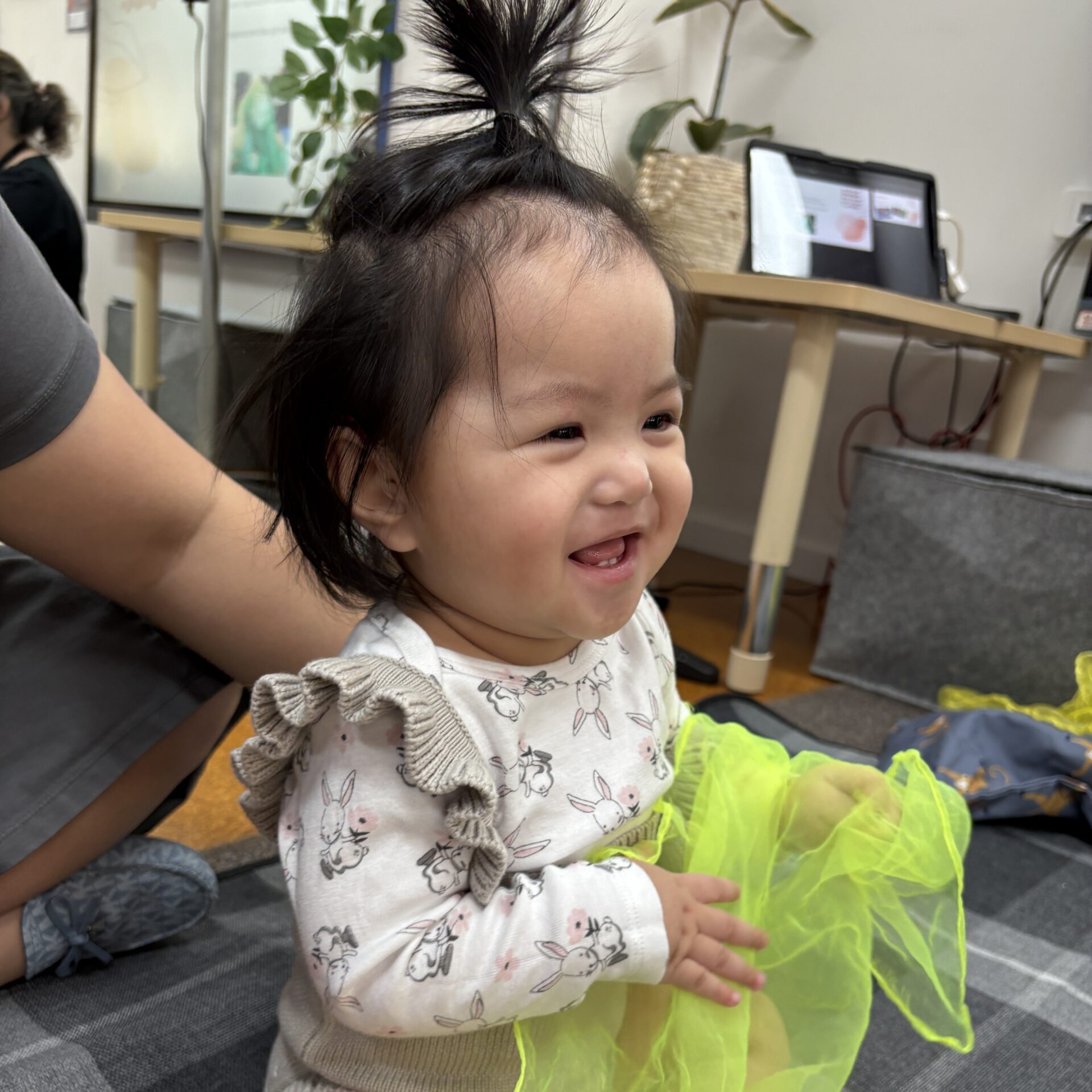 Young child smiling and holding a scarf