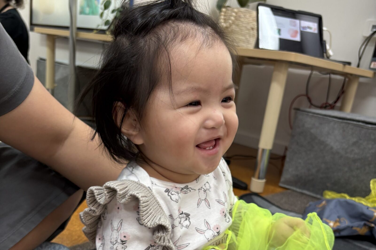 Young child smiling and holding a scarf