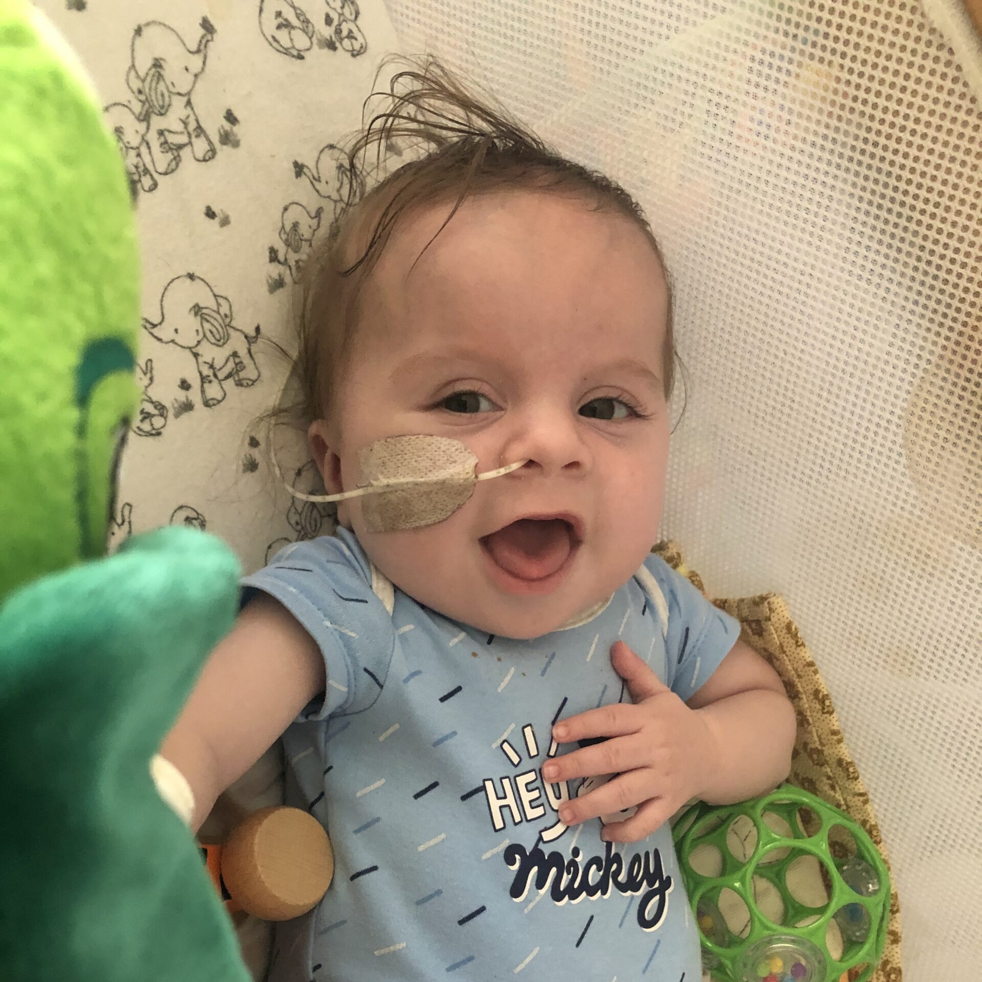 Young child with a blue onesie on smiling to camera