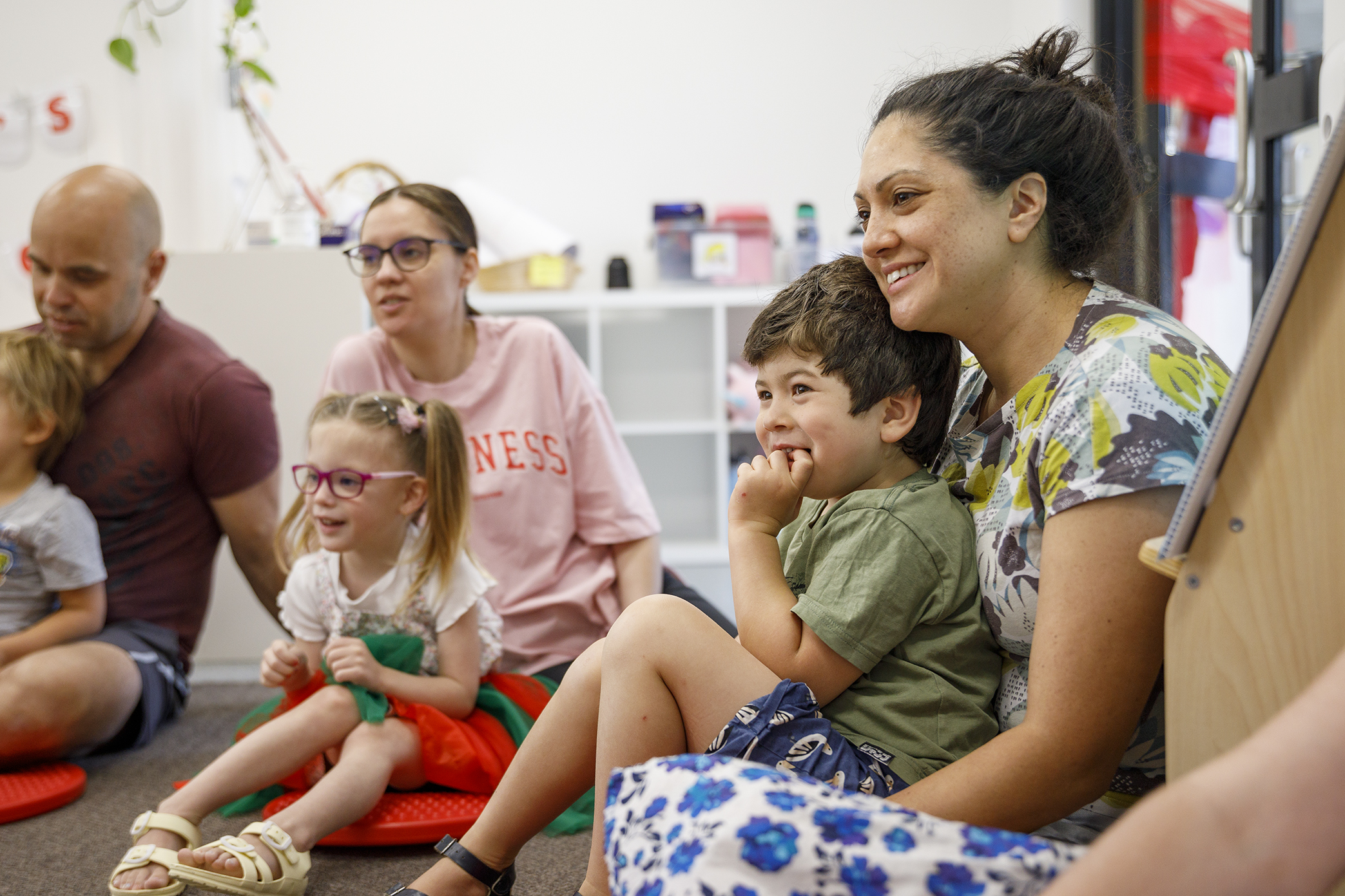 Children and families sitting in a circle during group therapy.