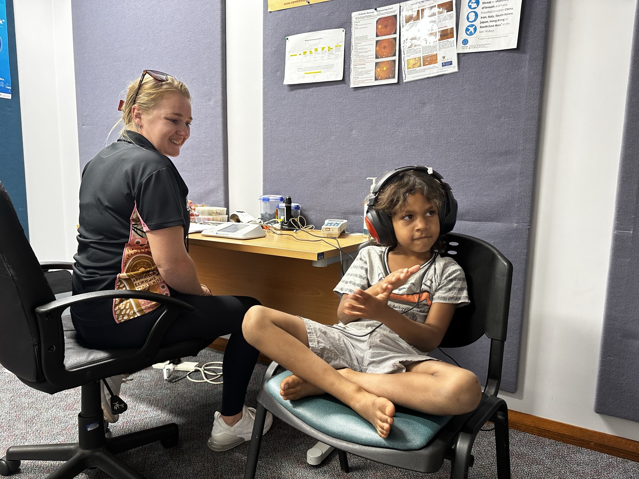 Child sitting on chair with headphones on having a hearing test