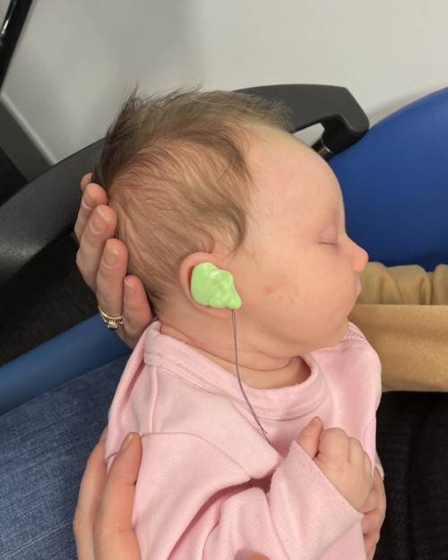 Baby Grace being held as her hearing aid moulds are fitted