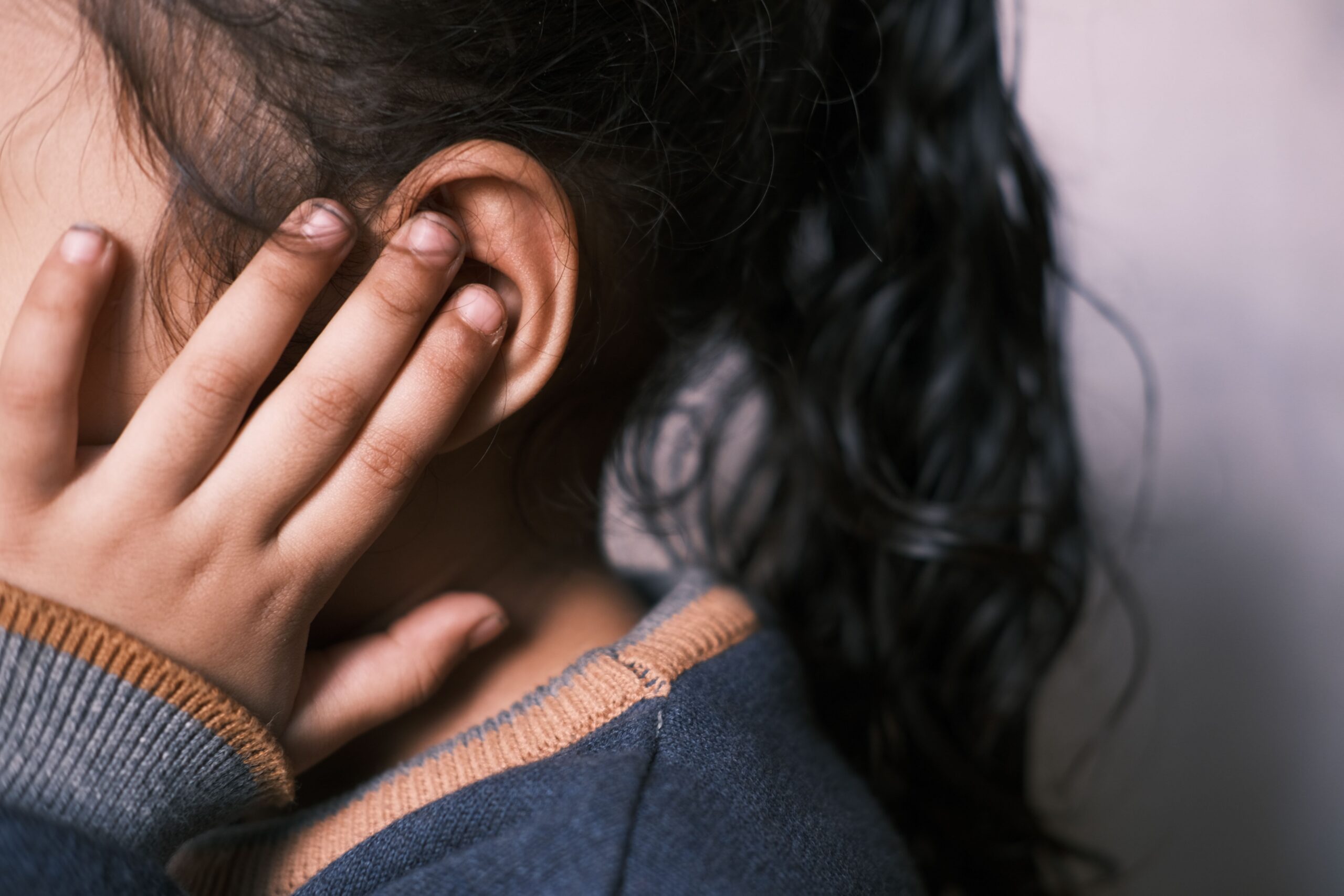 Young child holding their ear